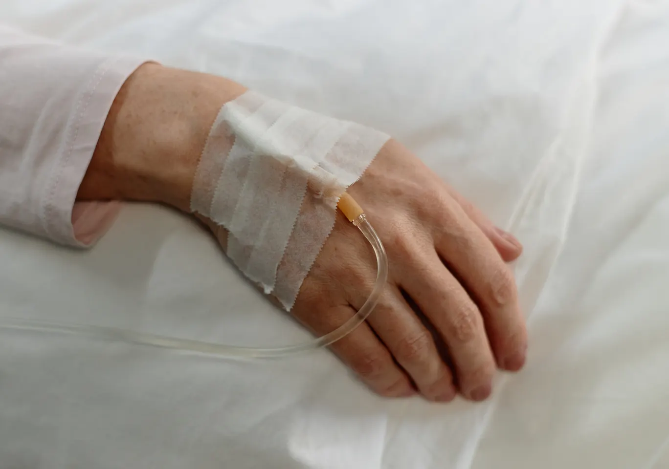 Kroplówki witaminowe Stary Sącz: dłoń z podłączoną kroplówką w spokojnym kadrze