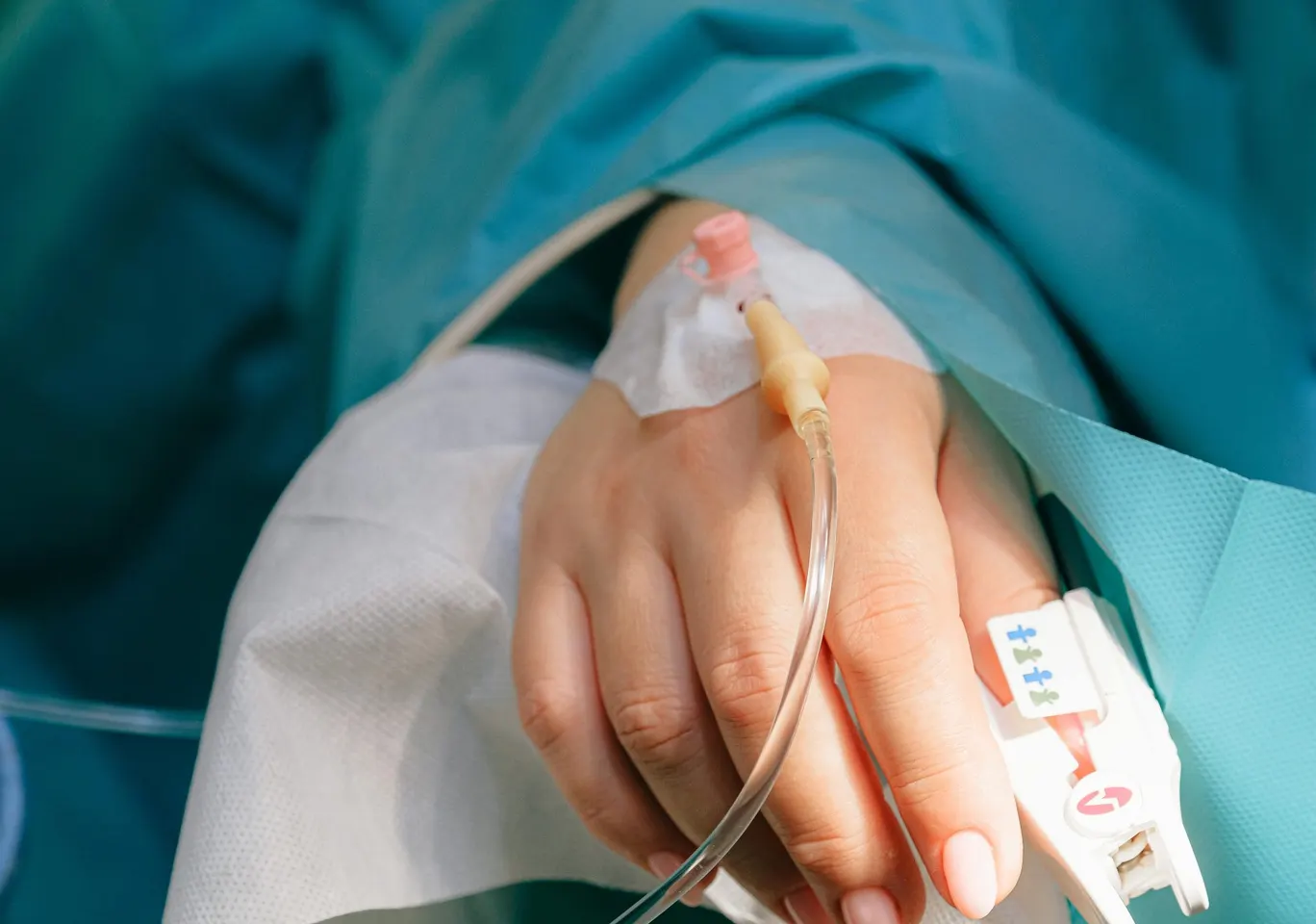 Detoks alkoholowy Limanowa: dłoń z wenflonem i pulsoksymetrem pod nadzorem